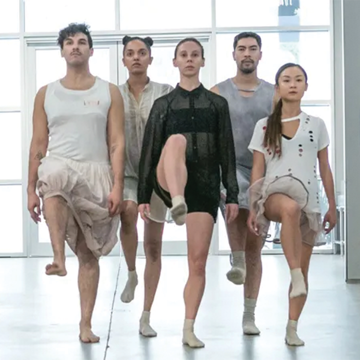 five dancers close together and all lifting one leg